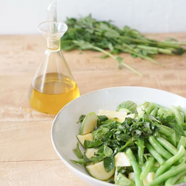 Una ensalada fresca que combina la suavidad de la calabaza con la textura crujiente de los ejotes y el toque tostado de los pistachos. La hierbabuena refresca, calma el sistema digestivo y ayuda a aliviar la pesadez, mientras que el perejil aporta minerales, favorece la eliminación de líquidos y da un aroma herbal vibrante que equilibra el conjunto. Los ejotes se consideran una legumbre ligera y al combinarse con los pistachos incrementan el aporte proteico del plato, sobre todo si se acompaña con un grano como quinoa o arroz. De esta forma la ensalada brinda saciedad sin pesadez. Es un acompañamiento versátil que puede servirse como la porción de verduras que construyen, que purifican y legumbres dentro de una comida completa, o como cena ligera para los días más cálidos. Es ideal en primavera y verano cuando el cuerpo agradece preparaciones frescas, verdes y con un toque cítrico y herbal que aligera la digestión.