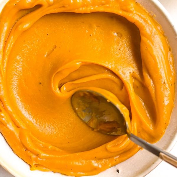 El camote es naturalmente dulce, suave y muy nutritivo. Asado lentamente en el horno, concentra aún más su sabor y desarrolla una textura cremosa que lo convierte en la base perfecta para un puré ligero pero saciante. Al mezclarse con ghee, sal y un toque de pimienta negra, se obtiene un acompañamiento sencillo y versátil, ideal para equilibrar cualquier comida. Puede servirse como guarnición junto con lentejas, verduras asadas, pollo, pescado o incluso como base para bowls más completos. Su dulzor natural lo hace especialmente agradable para niños y una forma fácil de incorporar un alimento constituyente y reconfortante en la mesa. Es ideal en otoño e invierno, cuando el cuerpo agradece sabores dulces, especiados y nutritivos.