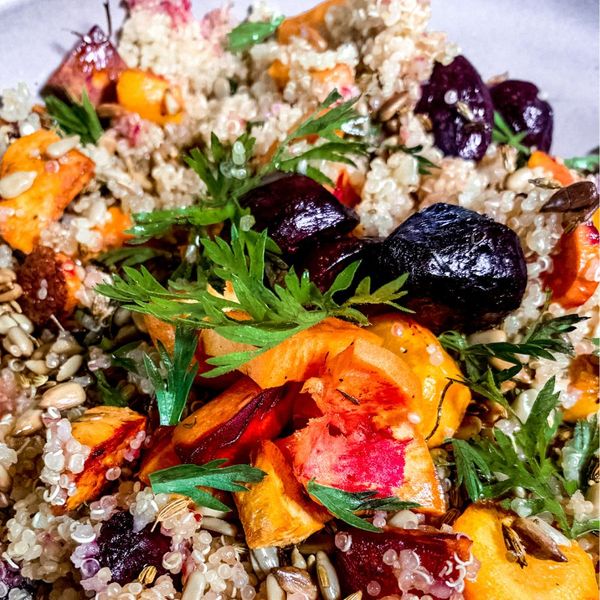 La quinoa es ligera y rica en proteína vegetal, se convierte en la base perfecta para esta ensalada tibia que combina raíces dulces y coloridas como el camote, la zanahoria y el betabel. Al saltearse con hinojo y romero, estas verduras no solo se vuelven más aromáticas, también más digestivas y reconfortantes. El ghee y las semillas de girasol tostadas añaden untuosidad y crocancia, mientras que el aderezo de aceite de oliva y limón (o vinagre balsámico) aporta un contraste fresco y ácido que equilibra el dulzor natural de las raíces. El resultado es un plato vibrante, saciante y lleno de texturas: perfecto como comida o cena ligera en sí mismo, o acompañado de ejotes o chícharos y una proteína animal para hacerlo más satisfactorio a la hora de la comida. También puedes añadir queso fresco y una verdura purificante para convertirlo en una comida completa. Es ideal en otoño e invierno cuando el cuerpo agradece raíces dulces, tibias y especiadas que nutren profundamente, pero también en primavera como ensalada templada de transición.