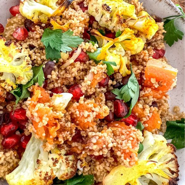 El couscous es un plato tradicional del norte de África que se ha convertido en un símbolo de comida comunitaria, nutritiva y versátil. En esta versión lo combinamos con calabaza y coliflor horneadas, que aportan dulzor natural, ligereza y una textura reconfortante. Los garbanzos o frijoles añaden proteína vegetal, haciendo que el plato sea más saciante y completo. Las especias como la canela, el comino y la cúrcuma no solo realzan los sabores, sino que también lo vuelven más digestivo y cálido. El toque cítrico de la naranja equilibra la untuosidad del ghee, dando un contraste fresco. El resultado es una ensalada tibia y aromática que se puede disfrutar como plato principal en la comida, o sin legumbres, como una cena ligera. Es ideal en otoño e invierno, cuando el cuerpo agradece preparaciones tibias, especiadas y con un toque cítrico que aporta vitalidad.