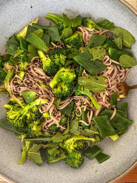 Una receta ligera y nutritiva que combina noodles de trigo sarraceno con verduras verdes y especias aromáticas. Estos noodles, también conocidos como “soba” en la tradición japonesa, se han usado en distintas culturas como alternativa más ligera al arroz o al trigo común. El trigo sarraceno de naturaleza seca y ligera, ideal en climas cálidos o húmedos y especialmente beneficioso para Kapha. El brócoli y los ejotes aportan frescura y cumplen la función de verduras purificantes dentro de la comida, mientras que el jengibre, el cardamomo y el comino negro estimulan suavemente la digestión y aportan calidez. La salsa de tamari, limón y miel equilibra sabores salados, dulces y ácidos, haciendo el plato versátil y sabroso. Para hacerlo una comida completa, puedes añadir calabacitas al vapor directamente con los noodles o servirlos acompañados de una crema de verduras que construyen, con o sin lentejas, ya que los ejotes funcionan tanto como verdura purificante como legumbre ligera. También combinan muy bien con pollo o pescado junto a verduras que construyen, y sí, se pueden mezclar sin problema los ejotes o los chícharos con proteína animal. Es ideal en primavera y verano, cuando el cuerpo agradece comidas ligeras, frescas y con un toque especiado que mantenga el fuego digestivo activo sin sobrecargar.