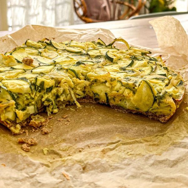 Una versión ligera, nutritiva y sin huevo del clásico quiche. Aquí la harina de garbanzo se combina con una crema vegetal a base de nuez de la India, logrando una textura suave y firme al mismo tiempo. El resultado es un plato rico en proteínas vegetales, grasas saludables y especias que equilibran la digestión. Los vegetales, hinojo, calabacitas y espinaca aportan frescura, ligereza y minerales, mientras que especias como cúrcuma, comino, hinojo y cilantro en polvo ayudan a hacer la preparación más digestiva y menos pesada. Es un plato versátil que funciona como comida principal completa o como desayuno nutritivo y diferente. Es ideal en invierno y primavera cuando el cuerpo agradece preparaciones tibias, especiadas y con buen aporte de proteína vegetal.