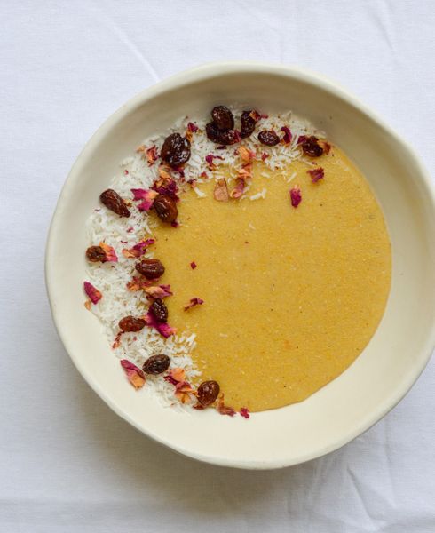 Este ha sido siempre uno de mis postres árabes favoritos, y confieso que le tomó un poco de tiempo (y la magia de un chef libanés en el Mar Muerto) a Rodrigo enamorarse también de él. Tradicionalmente, "Lebanese Nights" se sirve frío como postre, pero eso lo hace pesado y difícil de digerir, sobre todo después de una comida. En esta versión lo hemos transformado en una receta cálida, ligera y nutritiva, perfecta para el desayuno o la cena, especialmente para mujeres embarazadas, en postparto o para niños pequeños. En la tradición india existe una preparación muy parecida llamada "suji halwa", que también se usa como alimento de recuperación y fortaleza. Podríamos decir que este platillo es un verdadero puente entre las tradiciones árabe e india que une lo mejor de ambas culturas. El azafrán no solo da color y aroma, en Ayurveda se recomienda para fortalecer la sangre, mejorar la salud de la piel y apoyar a mujeres durante el embarazo, el postparto y la lactancia. Las pasas doradas en ghee aportan dulzor natural y son un tónico para la sangre y el sistema reproductivo. El cardamomo ayuda a la digestión y da ligereza, mientras que las almendras y el coco rallado enriquecen el plato con minerales, energía sostenida y grasas saludables. Este pudín de sémola es un recordatorio de que la comida puede ser medicina y memoria a la vez: reconforta al cuerpo, conecta con nuestras raíces y nutre a toda la familia con calidez y dulzura.