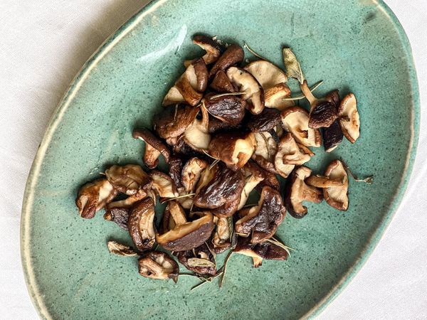 En los textos clásicos del Ayurveda, los hongos se describen como pesados, de naturaleza tamásica (pueden embotar la mente si se consumen en exceso) y capaces de generar más flemas, ya que crecen en ambientes húmedos y oscuros. Por ello, pueden ser difíciles de digerir, especialmente si se comen crudos, mal cocinados o fuera de temporada. Sin embargo, cuando se preparan de forma adecuada, bien cocinados, en pequeñas cantidades, acompañados de especias digestivas y ghee, sus cualidades cambian: se vuelven más cálidos, aromáticos y fáciles de asimilar. En la práctica moderna, ciertos hongos como shiitake, reishi o maitake incluso se consideran rasayana (rejuvenecedores) por sus beneficios inmunológicos y nutritivos. El shiitake en particular tiene un sabor dulce, es muy apreciado en la cocina oriental por su capacidad de fortalecer el sistema inmune, aportar minerales como zinc, hierro y cobre, y favorecer la vitalidad general. Esto lo hace equilibrante para Vata en pequeñas cantidades, adecuado para Pitta si se combina con especias suaves, y tolerable para Kapha si se prepara con especias picantes y digestivas como pimienta negra o jengibre seco. Es un plato ideal para el otoño y el invierno, cuando el cuerpo necesita calidez y fuerza. Puede servirse tanto en la comida como en la cena, como guarnición ligera (parte de las verduras construyentes por su sabor dulce), acompañado de granos como arroz, proteína animal, legumbres y otras verduras salteadas.