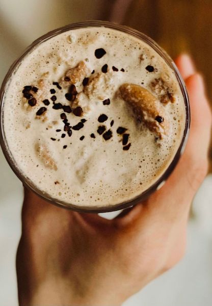 Este chocolate caliente es una versión inspirada en los clásicos chocolates After Eight, con la combinación irresistible de cacao y hierbabuena. La base de leche, enriquecida con un toque de ghee, lo hace más untuoso y digestivo, equilibrando el amargor y el calor del cacao que muchas veces puede desequilibrar especialmente a tipos de cuerpo como Vata y Pitta. Al mismo tiempo, el cacao aporta antioxidantes y un sabor profundo que reconforta en los meses fríos. La hierbabuena fresca se añade al final para conservar su aroma y frescura, equilibrando el dulzor natural del azúcar mascabado. El resultado es una bebida tibia, cremosa y aromática, que combina lo indulgente con lo ligero. Ideal para una tarde de invierno, como postre líquido que nutre tanto el cuerpo como el ánimo. Es ideal en otoño e invierno cuando el cuerpo agradece bebidas calientes, especiadas y suaves que reconfortan y alegran los sentidos.