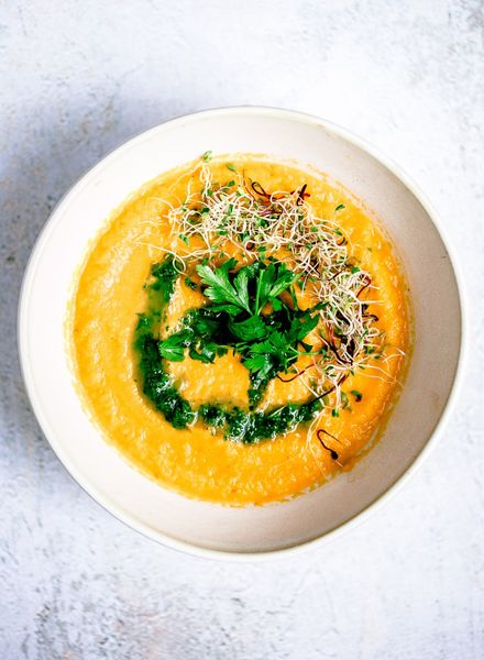 La sopa de zanahoria es un clásico reconfortante que nunca pasa de moda. En esta versión, las zanahorias se cocinan lentamente con jengibre y cilantro en polvo, lo que realza su dulzor natural y al mismo tiempo las hace más digestivas. Los tubérculos, por su naturaleza, ayudan a “aterrizar” en temporadas en las que la mente suele dispersarse, un alimento que nos conecta con la tierra siempre se agradece. El ghee aporta una textura sedosa y nutritiva, mientras que la pimienta negra da un contraste ligero que despierta el fuego digestivo y calienta el cuerpo. El toque especial está en los garbanzos asados: crujientes, especiados y aromáticos, que se convierten en el topping perfecto para añadir proteína, saciedad y textura a la suavidad de la crema. Esta combinación transforma un plato sencillo en una sopa completa, ligera y muy equilibrada. Puede acompañarse con arroz jazmín y hojas verdes salteadas para una comida más completa, o servirse tal cual, sin garbanzos, como una cena ligera. Es ideal en otoño (sin los garbanzos), invierno y primavera donde los garbanzos con su naturaleza seca pueden ayudar a que uno no acumule tanta retención de líquidos.