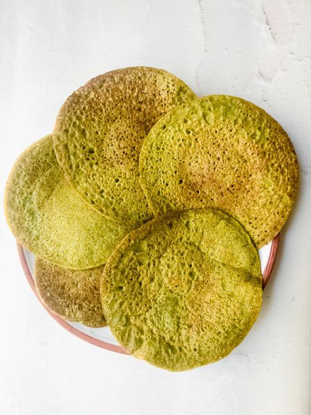 Si te gustan los desayunos salados y buscas algo rico en proteína pero fácil de digerir, este es para ti. Los frijoles mungo son un verdadero tesoro en Ayurveda: ligeros, nutritivos y una de las legumbres más fáciles de digerir. Son perfectos después de un entrenamiento o en esos días en los que despiertas con mucho apetito y necesitas algo que te sostenga de manera saludable. El jengibre y la cúrcuma activan la digestión y aportan calor, mientras que las hierbas frescas añaden frescura y aroma. El resultado son unos pancakes salados, dorados por fuera y suaves por dentro, que puedes acompañar con diferentes salsas o chutneys: chutney de hierbas, diosa verde o golden tahini. También combinan muy bien con hojas verdes salteadas, aguacate o verduras ligeras como calabacita y zanahoria. Son versátiles y se pueden disfrutar en cualquier época del año. En primavera y verano resultan depurativos y ligeros, perfectos para balancear Kapha. En otoño e invierno conviene servirlos con ghee extra y especias calientes para dar calor y estabilidad. Pueden disfrutarse tanto en el desayuno como a la hora de la comida, acompañados de arroz o quinoa y verduras para formar un plato completo.