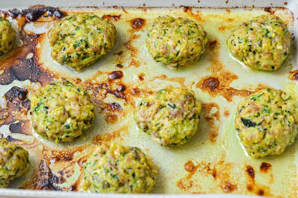 Un plato ligero, nutritivo y muy versátil que combina proteína animal con verduras frescas y especias digestivas. Las calabacitas ralladas aportan humedad y ligereza, mientras que el apio y el jengibre suman frescura y un toque estimulante para el agni. La cúrcuma y la asafétida (también conocida como hing o heng) son especias especialmente recomendadas al preparar carnes: la cúrcuma aporta propiedades antimicrobianas y antiinflamatorias, mientras que la asafétida ayuda a prevenir gases y a equilibrar el sistema digestivo, además de tener cualidades que ayudan a reducir la proliferación de bacterias no deseadas. Juntas hacen que el pollo sea más fácil de digerir y menos propenso a generar pesadez. Si no tienes acceso a asafétida, puedes omitirla sin problema. Al hornearse con un poco de ghee, estas tortitas quedan jugosas por dentro y ligeramente doradas por fuera, sin necesidad de freírlas. Son perfectas como plato principal acompañadas de arroz blanco y hojas verdes salteadas, formando una comida completa y balanceada. Son ideales en cualquier estación, cuando se busca un plato tibio, especiado y fácil de digerir.