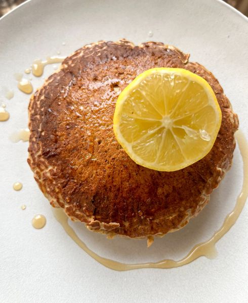 Estos pancakes son una versión nutritiva y ligera de un clásico desayuno. La harina de trigo sarraceno les aporta minerales y un carácter más seco y digestivo que las harinas convencionales, mientras que el limón, el cardamomo y el hinojo les dan un aroma fresco y especiado. La ricotta (o paneer fresco) es el ingrediente estrella: rica en proteínas y de fácil digestión cuando se consume en preparaciones ligeras, hace que estos pancakes sean más saciantes y nutritivos. Gracias a ello, se convierten en un desayuno perfecto para niños en crecimiento o para adultos en esos días de mucho apetito cuando se necesita algo que sostenga la energía sin ser pesado. Son ideales en invierno y primavera, cuando el cuerpo agradece desayunos tibios, aromáticos y con un buen balance entre proteína y ligereza.
