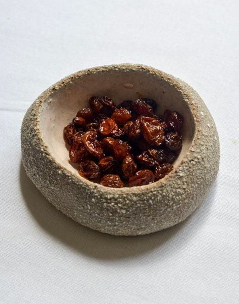 Las pasas fritas en ghee son un remedio tradicional en Ayurveda para cuando la digestión está lenta, el tránsito se vuelve irregular o hay sequedad interna, señales claras de un aumento de Vata en el colon. Al calentarse en ghee, las pasas se inflan y recuperan jugosidad, aportando humedad natural y fibra soluble que suaviza y lubrica las heces, facilitando su movimiento sin irritar el intestino. El ghee nutre profundamente los tejidos y calma el sistema nervioso asociado al movimiento del colon, mientras que el hinojo o el cardamomo ayudan a reducir gases, hinchazón y fermentación excesiva. Es un remedio pequeño pero poderoso que mejora el tránsito intestinal, calma el vientre nervioso o contraído, lubrica sin causar pesadez, reconforta en épocas de estrés, viajes o posparto y da dulzor nutritivo y medicina al mismo tiempo. Es perfecto para niños, postparto y personas con digestión débil o estreñimiento por sequedad.