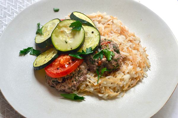 Inspiradas en los sabores del Mediterráneo oriental, estas tortitas de cordero son un plato sustancioso, aromático y a la vez equilibrado. El cordero, al ser una carne cálida y nutritiva, es ideal para las estaciones frías o para quienes necesitan fuerza y vitalidad. Combinado con cúrcuma y asafétida se vuelve más ligero y fácil de digerir, mientras que las verduras, calabacitas y jitomate aportan frescura, humedad y equilibrio. Y aunque casi nunca uso jitomate, en este caso un poco hace una gran diferencia: realza el sabor, da jugosidad y crea un ligero caldo en el fondo del refractario… no lo dejes atrás, mézclalo con tu arroz al servir, es simplemente exquisito. Al hornearse con ghee, las tortitas quedan tiernas por dentro y doradas por fuera, sin necesidad de freír. Es un plato perfecto para una comida completa junto con arroz basmati o quinoa. Ideal para otoño e invierno cuando el cuerpo necesita calor estable, nutrición profunda y comidas cocidas que aporten fortaleza sin pesadez.