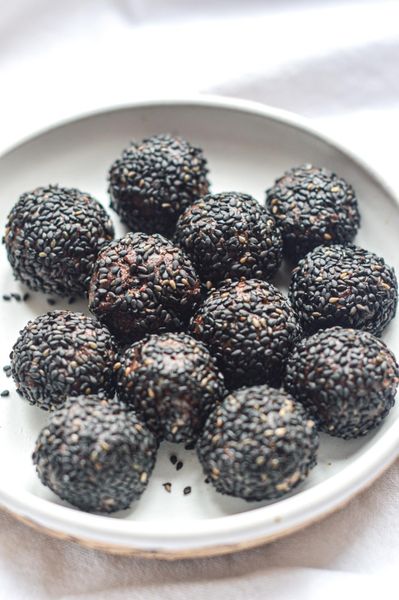 Estas bolitas nacen de uno de esos ingredientes que Ayurveda valora muchísimo en los meses fríos: el ajonjolí. Las semillas de ajonjolí, y el tahini hecho a partir de ellas, son profundamente nutritivas, cálidas y enraizantes. En Ayurveda se consideran especialmente importantes para nutrir los tejidos más profundos del cuerpo, en especial, huesos y cabello (que se entiende como una manifestación de la salud ósea). El invierno es una temporada donde el cuerpo tiende a secarse más, donde las articulaciones pueden sentirse más rígidas y donde necesitamos alimentos que aporten lubricación, estabilidad y nutrición profunda. El sésamo hace exactamente eso: aporta minerales, grasas de buena calidad y una sensación de sostén muy marcada, algo que el cuerpo agradece muchísimo cuando hace frío. Son un snack pequeño pero muy nutritivo, ideal para invierno, para después de comer o como un pequeño boost de energía cuando el cuerpo pide algo dulce, pero real y satisfactorio.