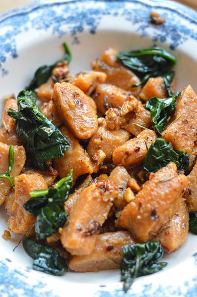 Tengo que ser honesta con esta receta: la primera vez que intenté hacer gnocchis de camote fue hace unos 9 años… y fallé. No me salieron como esperaba y siendo sincera, no quise volver a intentarlo durante mucho tiempo. Hasta hace poco. Volví a probar con más paciencia, menos expectativas y entendiendo que este tipo de recetas requieren práctica. Y valió la pena. Son deliciosos, pero también te enseñan algo: a cocinar con calma, a ajustar sobre la marcha y a aceptar que la textura puede variar hasta que encuentras tu punto ideal. El camote es naturalmente dulce, suave y muy enraizante. Combinado con harina integral y especias cálidas, se vuelve un plato reconfortante pero relativamente ligero si se maneja bien la cantidad de harina. El ghee con nuez y hierbas aporta profundidad, grasas de buena calidad y ese aroma que hace que el plato se sienta completo. Desde la mirada ayurvédica, esta es una comida que nutre y satisface. El camote aporta energía estable, el ghee ayuda a la digestión y a la absorción de nutrientes, y las especias evitan que el plato se vuelva pesado. Es una preparación ideal para otoño, invierno y comienzos de primavera, cuando el cuerpo agradece alimentos cálidos y sustanciosos. No es una receta “rápida”, pero sí una de esas que te invitan a cocinar con presencia. Y cuando salen bien, se sienten como un pequeño logro en la cocina.