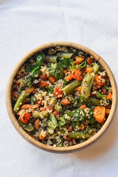Las habas tienen una temporada corta y esta receta es una forma sencilla y muy completa de aprovecharlas, cereal, legumbre y verdura en un solo plato, sin que se sienta pesado ni complicado.
El bulgur es un cereal ligero y de cocción rápida, lo que lo hace ideal para esta época. Las habas, bien salteadas con las especias, aportan proteína y sustancia sin la pesadez que pueden tener otras legumbres. Las zanahorias equilibran con un toque dulce y terroso, y la albahaca fresca al final lo levanta todo, le da esa sensación de frescura que caracteriza a los platos de primavera.
Las especias, hinojo, cardamomo, cilantro y cúrcuma, están ahí para que todo se digiera bien. No dominan el sabor, simplemente hacen su trabajo en segundo plano. El resultado es un plato fresco, equilibrado y fácil de integrar en el día a día de esta temporada.

